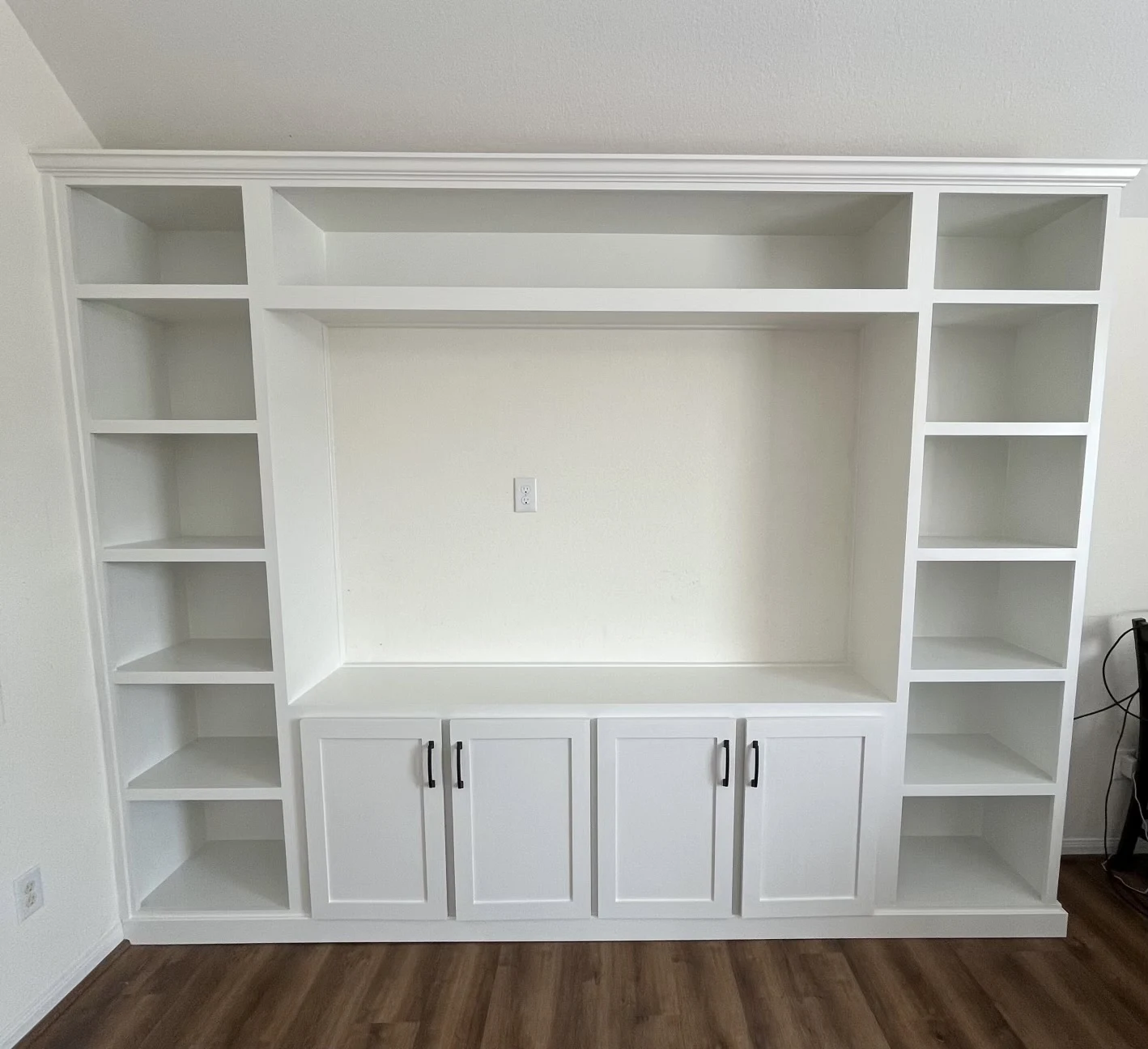 After: completed white custom built-in cabinetry with open shelves, crown molding and four base cabinet doors