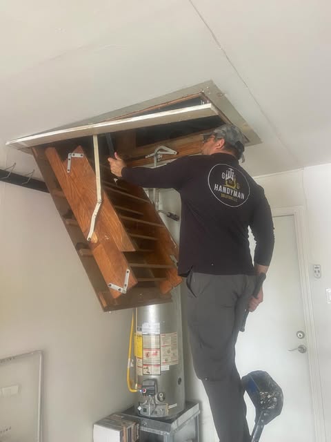 GG Handyman worker installing attic access stairs